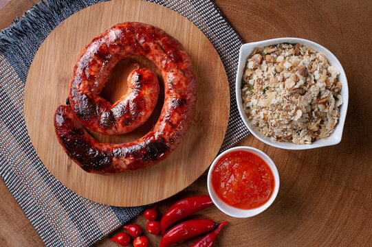 ..Grilled Brazilian sausage stuffed with cheese on a wooden board. Brazilian barbecue. Top view. Selective focus