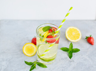 Refreshing summer lemonade in a glass cup from lemon, lime, strawberry, orange, mint on a white background. Flax drinks. Detox, healthy eating, fitness drinks. Copy space.