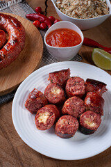 .Grilled Brazilian sausage stuffed with cheese on a wooden board. Brazilian barbecue.. Selective focus