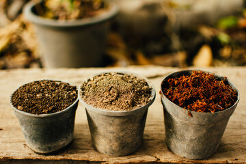 Top view of material for planting seeds (soil, organic manure, coconut coir husk fiber) in plastic pots.
