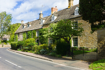 Row of characteristic honey coloured stone Cotswold cottages in Kingham, Oxfordshire, England