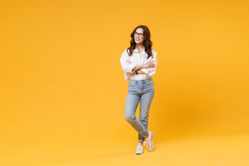 Smiling young brunette business woman in white shirt glasses isolated on yellow background studio....