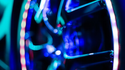 Blurred arcade machine game. Closeup of a car simulator tire with neon lights.
