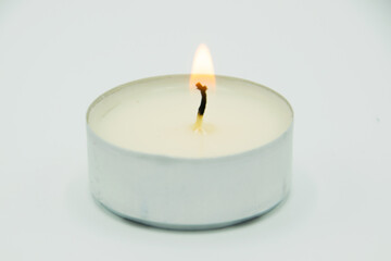 burning wax candle on gray background