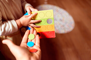 Baby plays with his father colored chips.