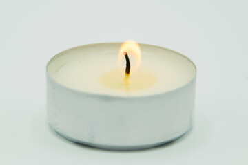 burning wax candle on gray background
