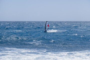 Windsurfing sails on the blue sea