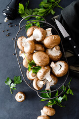 Raw mushrooms champignons on black background, cooking fresh champignons.