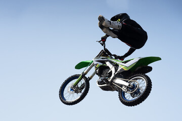 Fototapeta na wymiar man in a helmet performs a stunt in the air on a motorcycle