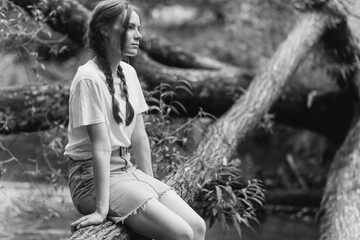 Art black and white portrait girl with pigtails outdoors in a forest