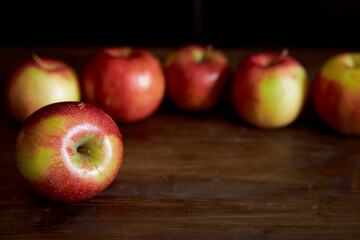Red apples on a brown table. Close-up.