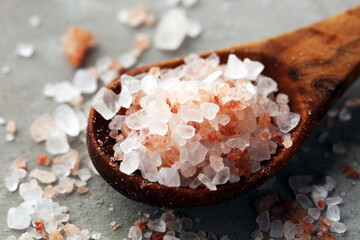 Fototapeta na wymiar Sea salt and himalayan on spoon. Crystals of salt on background