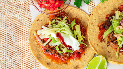 Mexican traditional authentic homemade tacos with pulled pork beef chili con carne serve with tomato salad and avocado guacamole and dip sauce