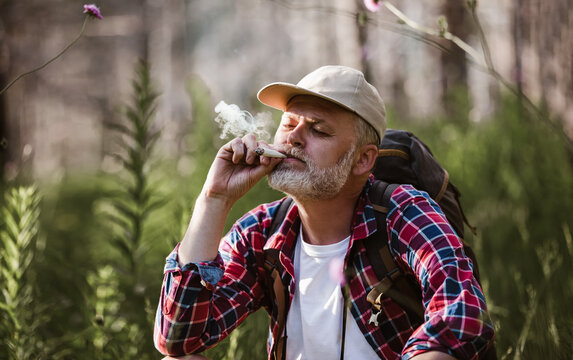 Bearded Mature Man Smoking Medical Marijuana In Nature.