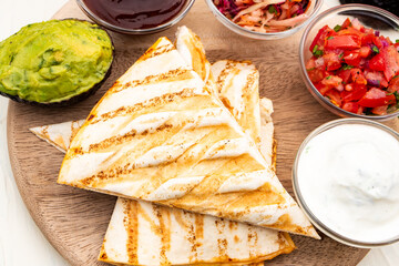 Mexican traditional authentic homemade quesadilla with pulled pork beef chili con carne serve with tomato salad and avocado guacamole and dip sauce