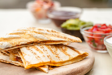 Mexican traditional authentic homemade quesadilla with pulled pork beef chili con carne serve with tomato salad and avocado guacamole and dip sauce