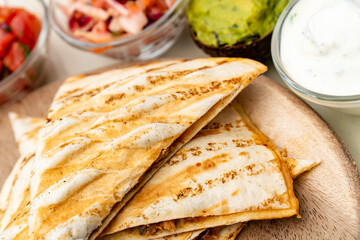 Mexican traditional authentic homemade quesadilla with pulled pork beef chili con carne serve with tomato salad and avocado guacamole and dip sauce