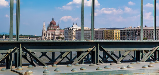 The Parliament Building in Budapest framed by the supports of the Chain Bridge across the River Danube in Budapest  summertime