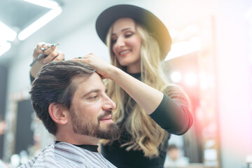 Fototapeta premium Hair stylist trying to get her client a proper cut