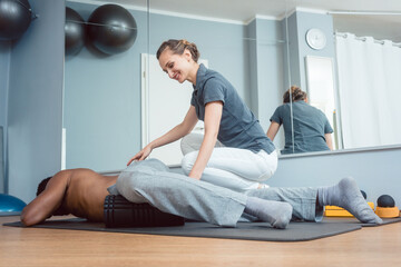 Young man doing fascia training with roll