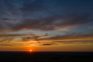 Beautiful aerial shot of orange sunset and blue sky over horizon