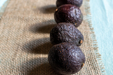 row of ripe avocados on rustic background 