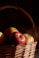 Braided basket with red apples on a black background