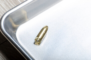 a brass bullet sits on sterile stainless steel tray