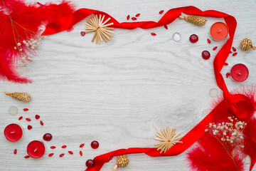 Composition of red closeupand candles with little white flowers on light wooden board