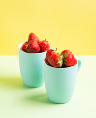 Red strawberries in blue circles on a light green and yellow lime background, horizontal orientation, side view, closeup.