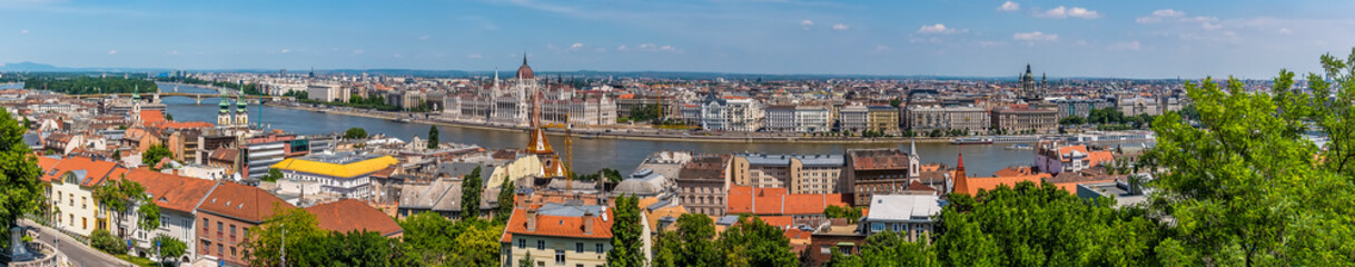 Naklejka na ściany i meble A panorama view of Buda and Pest districts in Budapest from the Fisherman's Bastion in the summertime