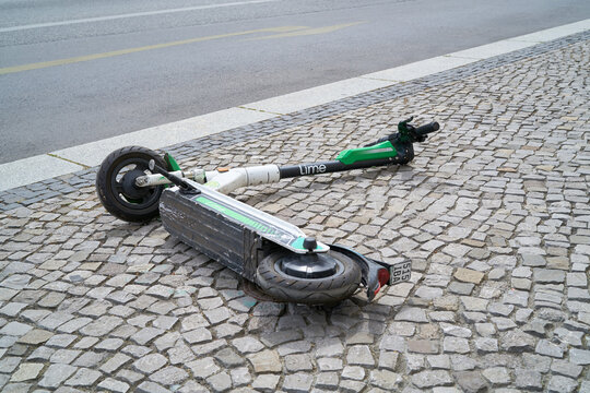 Ein E-Scooter der Firma Lime liegt am Stra&szlig;enrand in der Innenstadt von Berlin 