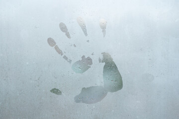 Handprint on wet window abstract background.