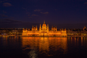 Aerial drone shot of Hungarian Parliament with lights on during Budapest evening
