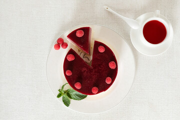 Composition on a light background, a dish with mousse cake and a Cup of red tea karkade. The concept of proper dietary nutrition and cake day. Selective focus.