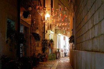 Shops in a narrow alley in the port city of Porec in Croatia in the evening