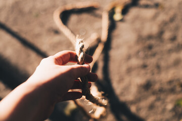 Hand holding a braided quality, biodegradable, and strongest rope made from Abaca also known as Manila hemp.  Selective focus. Copy space. Personal perspective.
