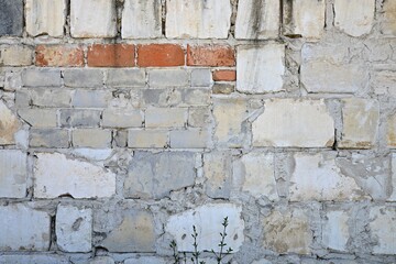 Old, many times managed wall of various building materials. Wall of different bricks and blocks. Wall in old factory district.