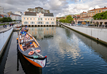 Obraz premium Colorful Moliceiro boat rides in Aveiro are popular with tourists to enjoy views of the charming canals.