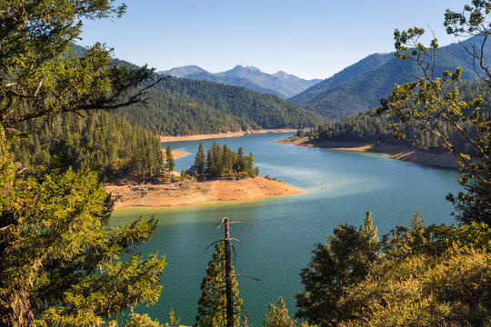 Beautiful landscape with turquoise water of a mountain lake in the foreground and a mountain range in the background. View from above in golden hour.  Location is Applegate Lake in Oregon, USA 