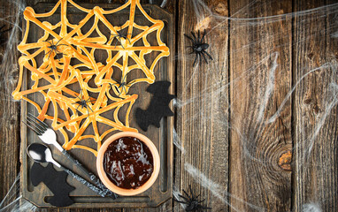 Halloween dessert pancakes spider web with jam. Scary halloween. View from above. Copy space.