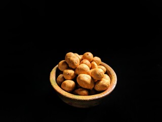 Japanese peanuts served in a clay bowl on black background. asian food concept