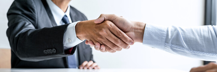 Male candidate shaking hands with Interviewer employer after a job interview - obrazy, fototapety, plakaty