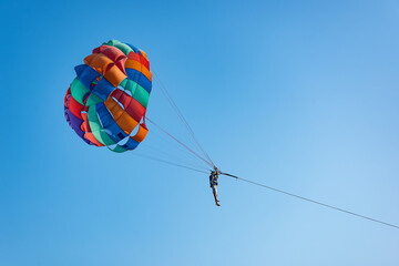 Parasailing above the ocean at tropical islands. Copy space, holiday fun activities. Thailand/Phuket