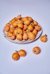 Medlars in a wooden plate and on the table
