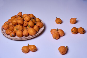 Medlars in a wooden plate and on the table