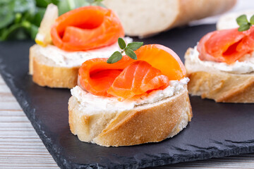 Salmon mini sandwiches on black slate board