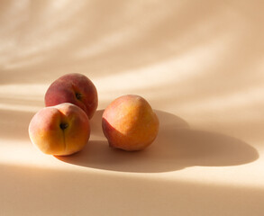 Fresh peaches on a pastel background with shadows
