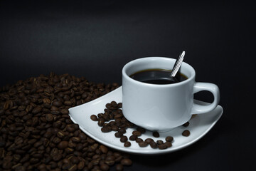 Coffee cup and coffee beans on black background