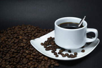 Coffee cup and coffee beans on black background